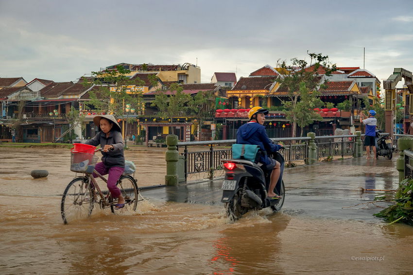 Hoi An po przejściu orkanu, Wietnam, most pod wodą, rowerzyści w wodzie
