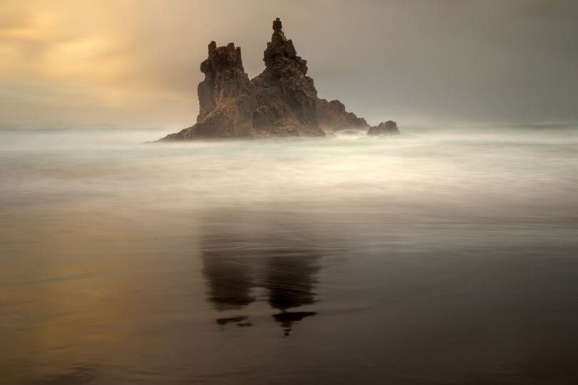 Fotografowanie wybrzeża, odbicie skały w mokrym piasku, jak fotografować morze